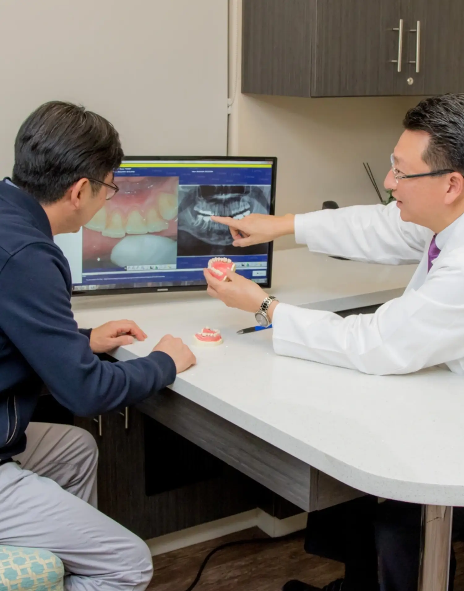 A dentist examines a patient lying in a dental chair